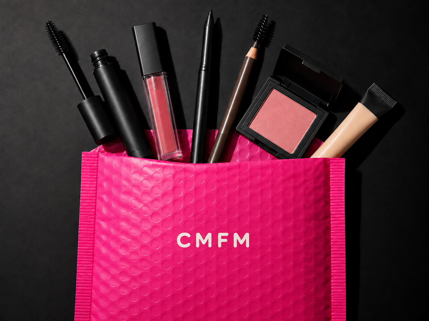 A simple pink CMFM mailer filled with everyday makeup essentials